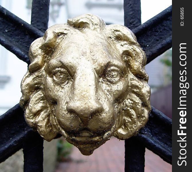 golden metal lion head at an entrance. golden metal lion head at an entrance