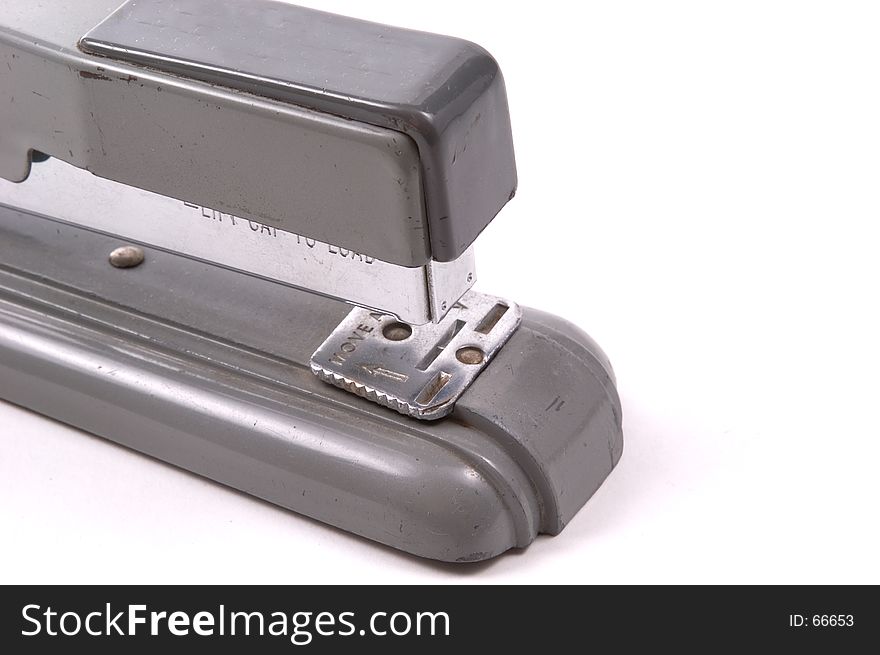 Close up of an old desk stapler, grey metal on white background. Close up of an old desk stapler, grey metal on white background.