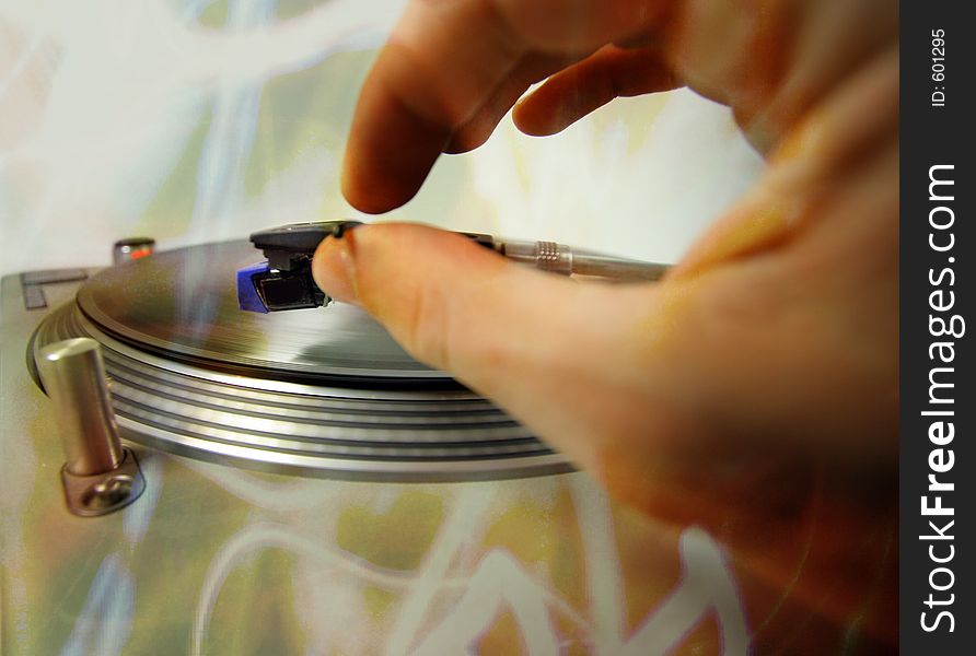 A hand putting a needle on a record. A hand putting a needle on a record