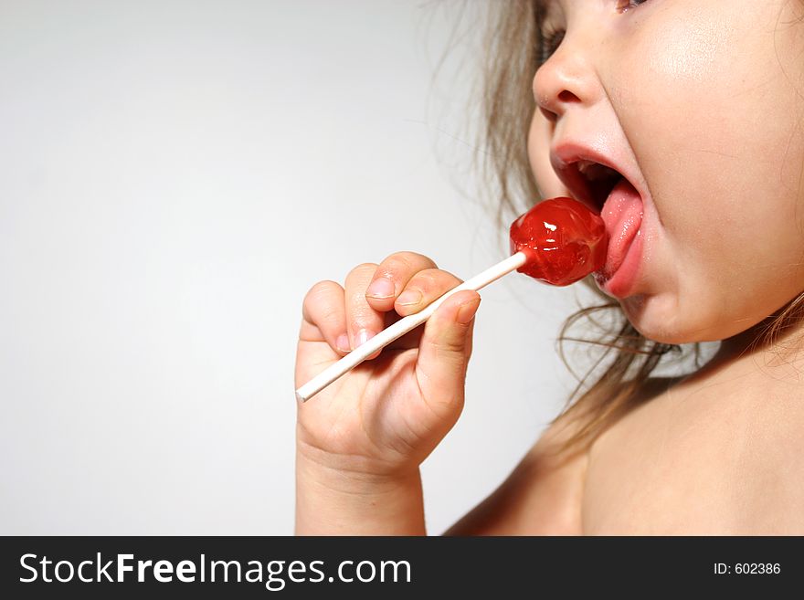 Young child enjoying a lollipop. Young child enjoying a lollipop