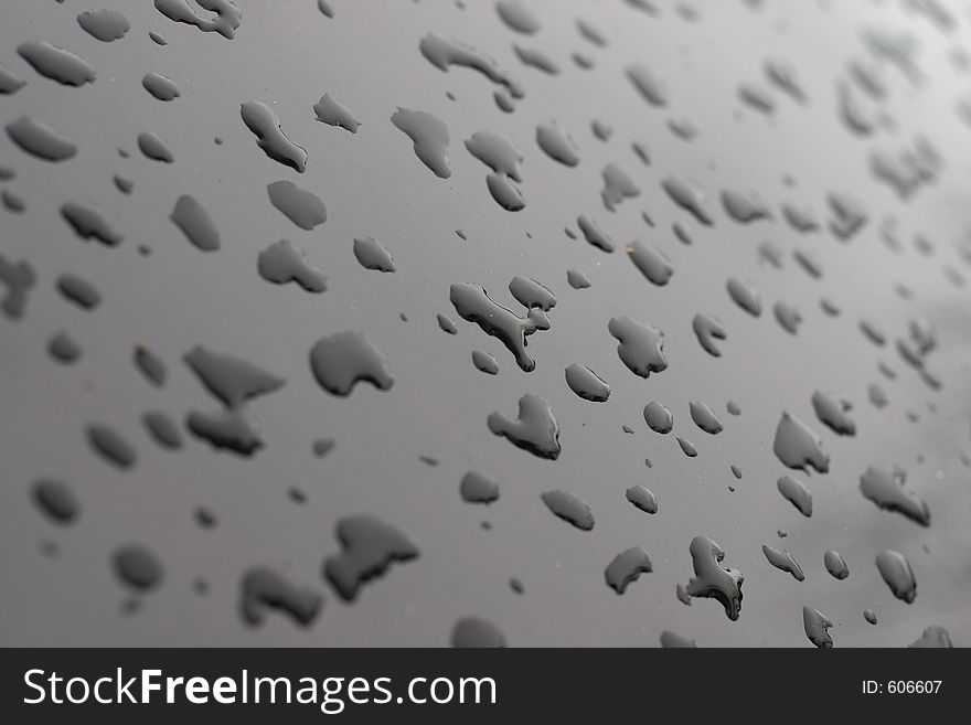 Water droplets on black paint. Water droplets on black paint.