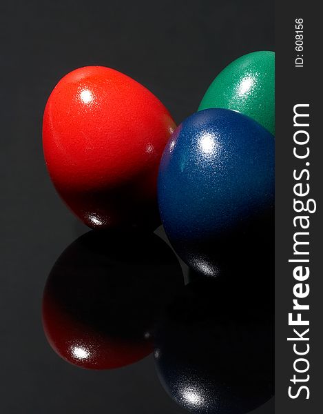 Three different coloured eggs on black background. Three different coloured eggs on black background