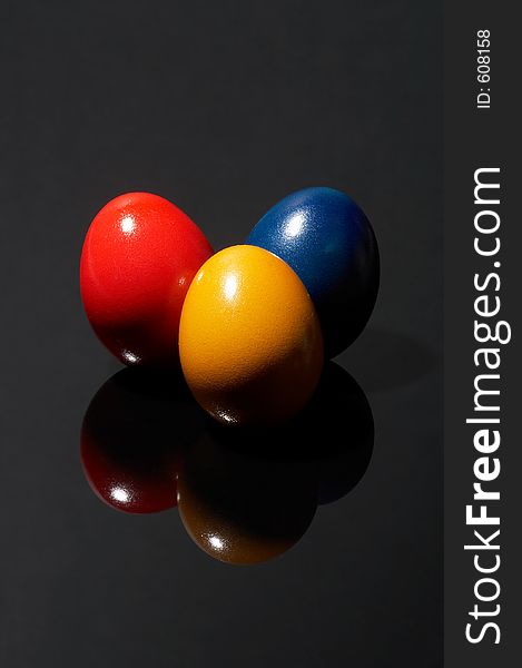Three different coloured eggs on black background. Three different coloured eggs on black background