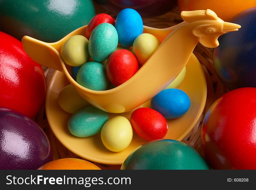 Choco eggs in a eggcup on coloured eggs. Choco eggs in a eggcup on coloured eggs