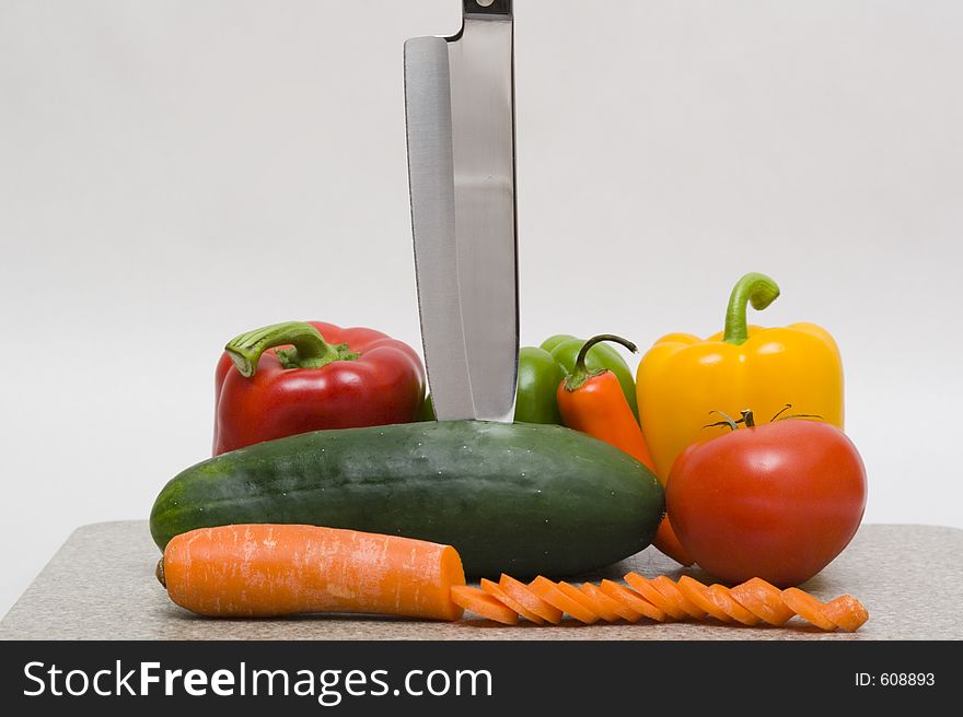 A cutting board with vegetables and a knife. A cutting board with vegetables and a knife