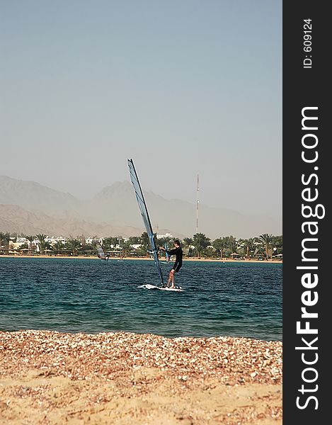 Man practicing in windsurfing in calm weather. Laguna near Dahab town, Sinai, Egypt. Man practicing in windsurfing in calm weather. Laguna near Dahab town, Sinai, Egypt