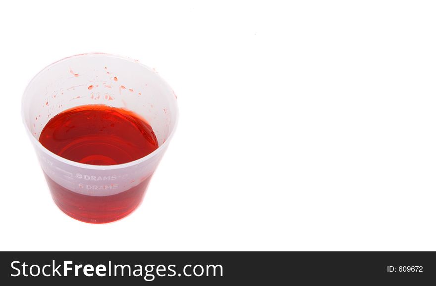 Small dose cup with cough syrup and copy space to the right