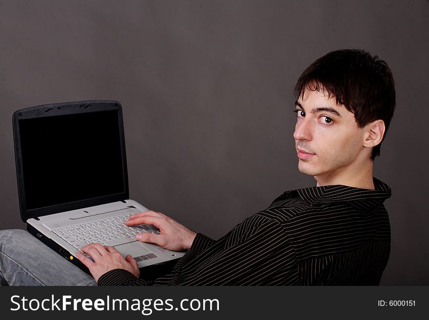 Casual Young Man Sitting With Laptop