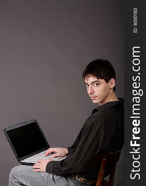 Casual Young Man Sitting With Laptop