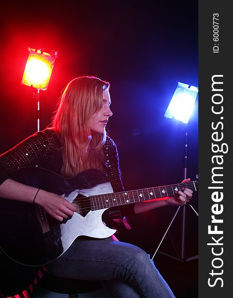 Woman playing guitar on stage