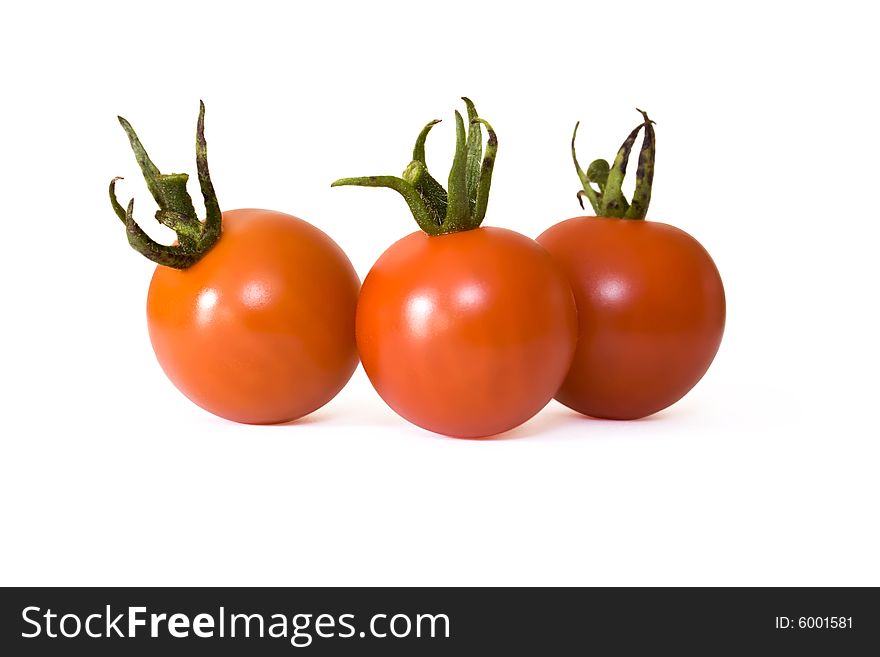 Three red cherry tomatoes isolated on white background. Three red cherry tomatoes isolated on white background