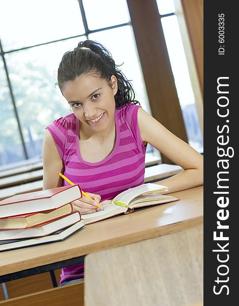 Young beautiful student in college studing in library