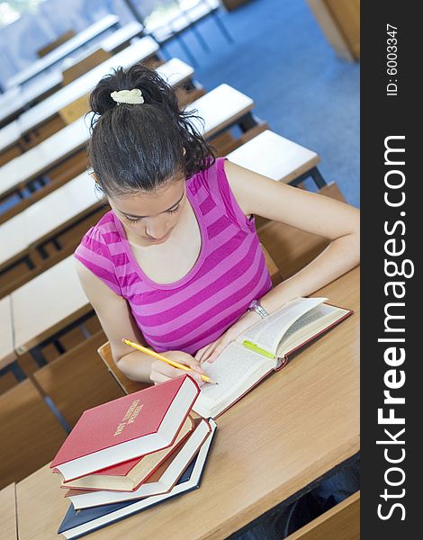 Young beautiful student in college studing in library