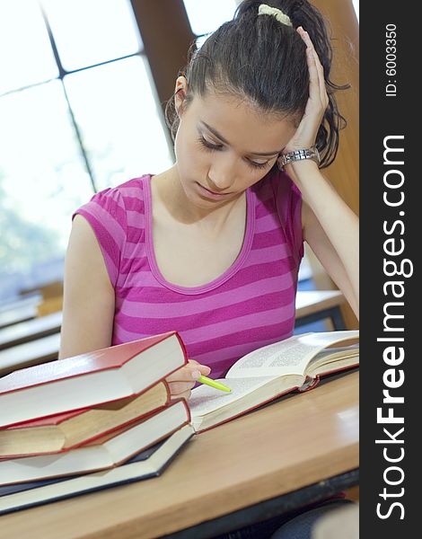 Young beautiful student in college studing in library