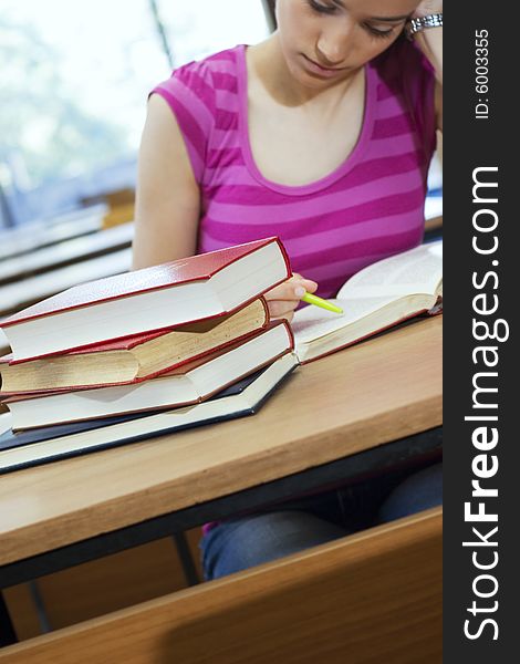 Young beautiful student in college studing in library