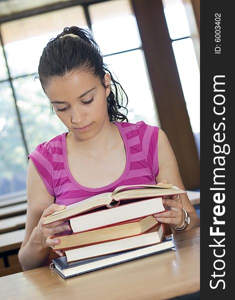 Young beautiful student in college studing in library