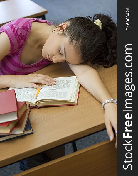 Young beautiful student in college sleeping in library