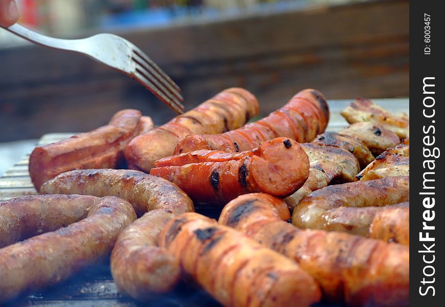 Close-up of grilled sausages on wire rack. Focus on center.