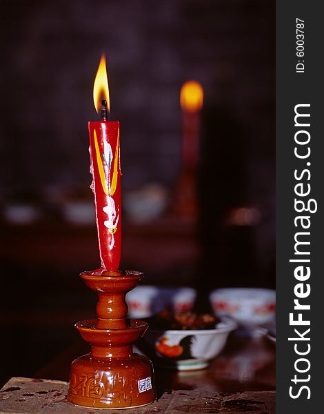A red chinese candle burning at a sacrificing ceremony. A red chinese candle burning at a sacrificing ceremony