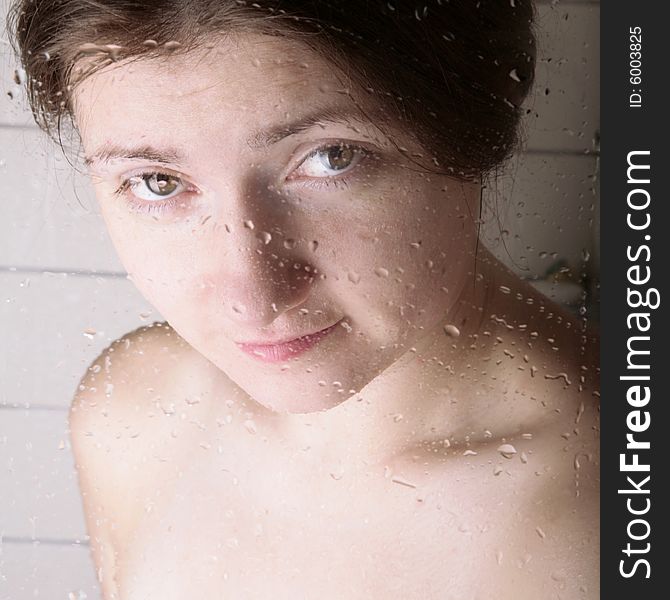 Young woman looking through the shower cabin glass. Young woman looking through the shower cabin glass