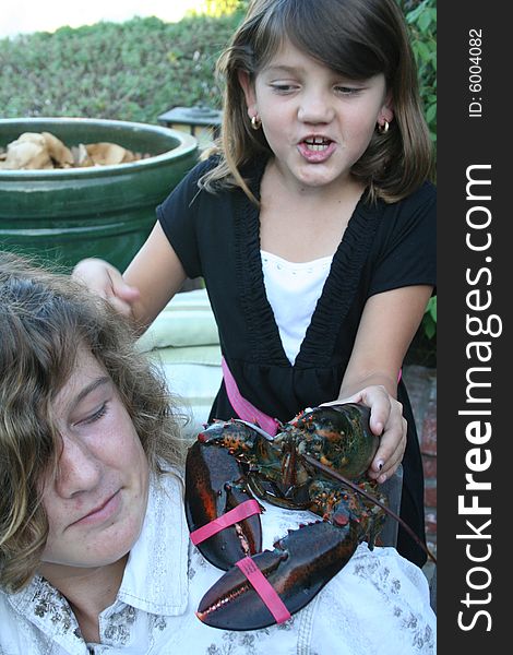 Girl holding a lobster over her brother's sholder. Girl holding a lobster over her brother's sholder.