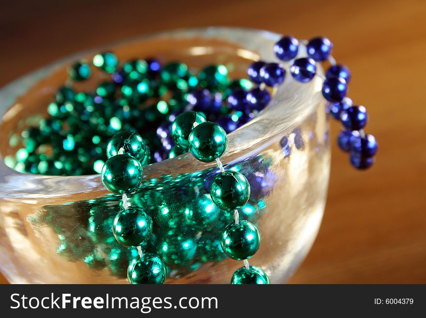 Necklace with green and blue pearls in a bowl