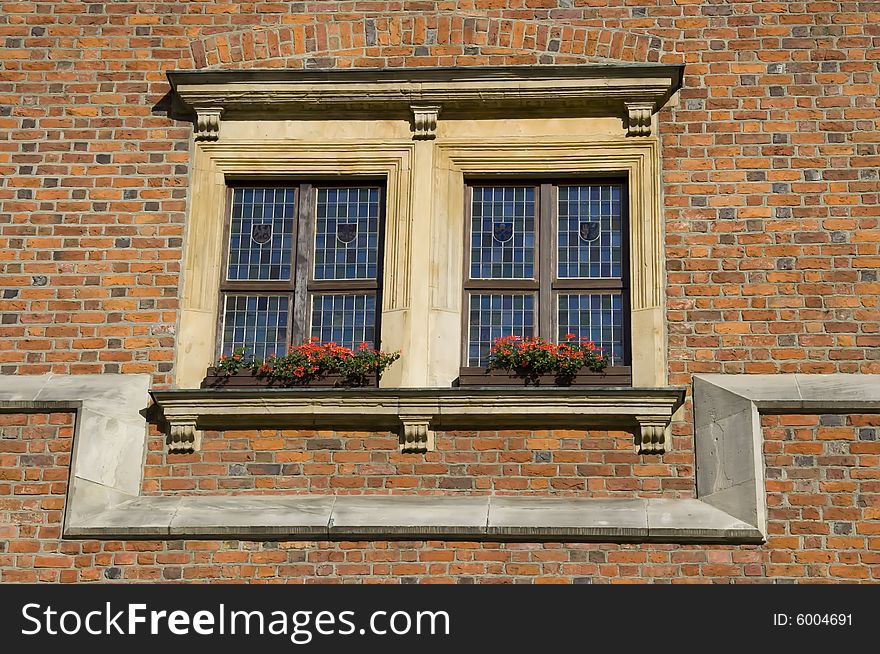 Double window over red brick wall