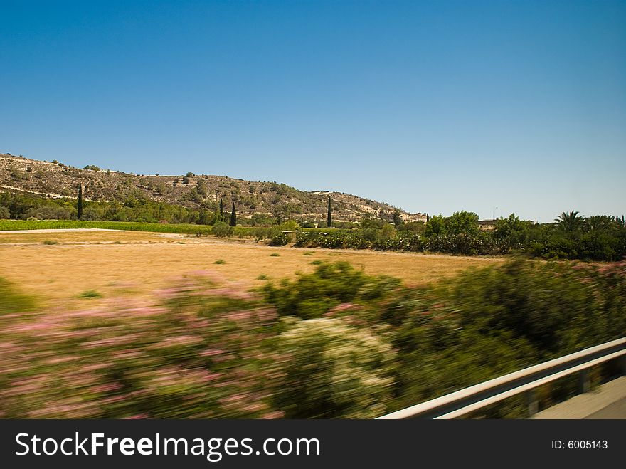 This view from road to dry landscape with hills far away