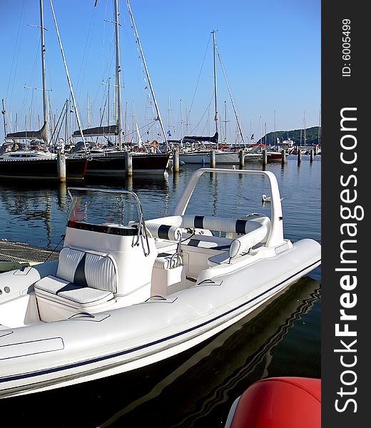 White motor boat moored in harbour.