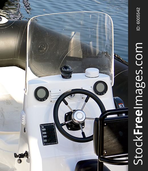 The motor boat wheel and control panel close up. The motor boat wheel and control panel close up.