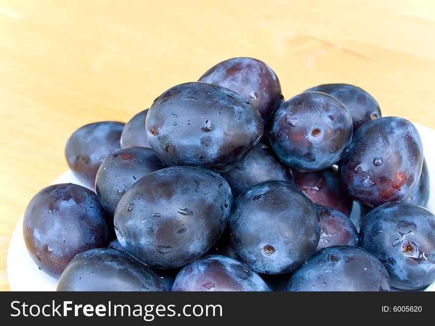 Stack of Plums on wooden background.