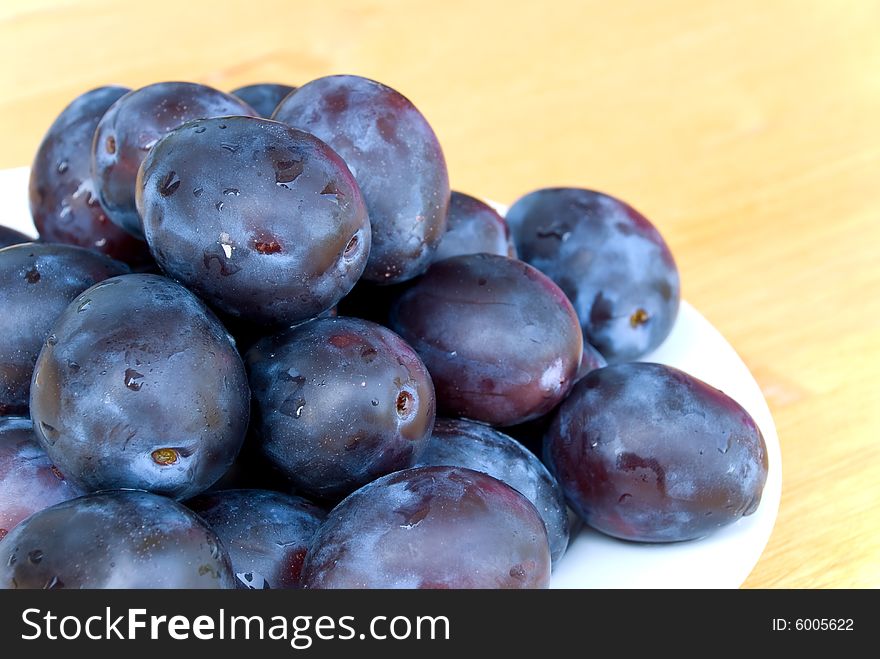Stack Of Plums On Wooden Background
