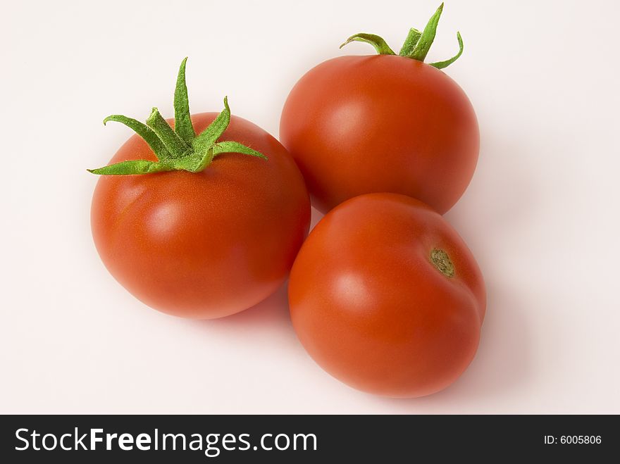 Three ripe tomatoes on the white background