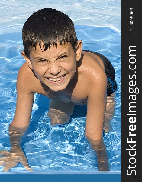 Cute young boy in pool smiling