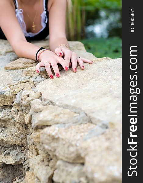 Young girl lying at stone, just hands and breast are visible. Young girl lying at stone, just hands and breast are visible