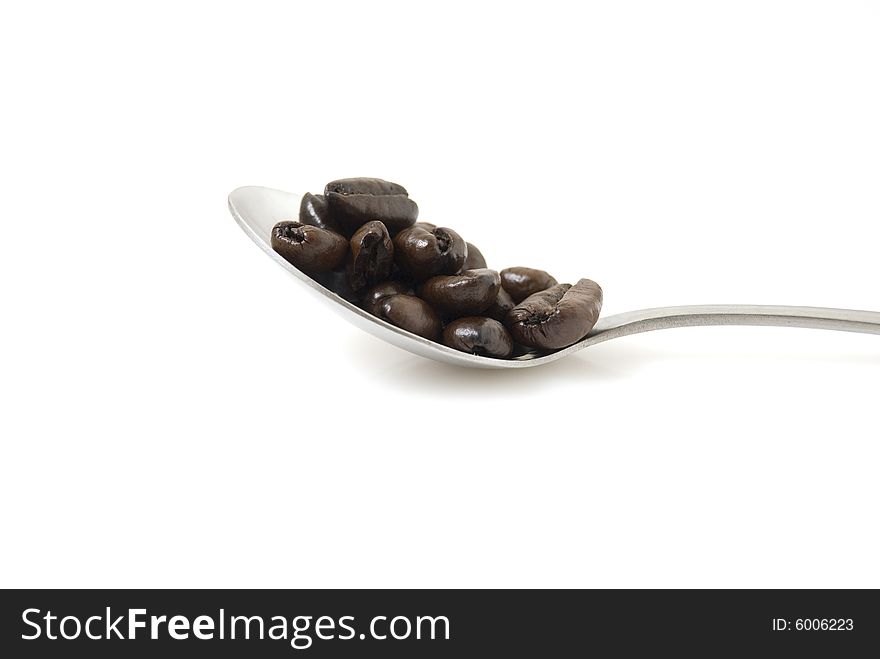 Closeup shot of coffee beans on teaspoon