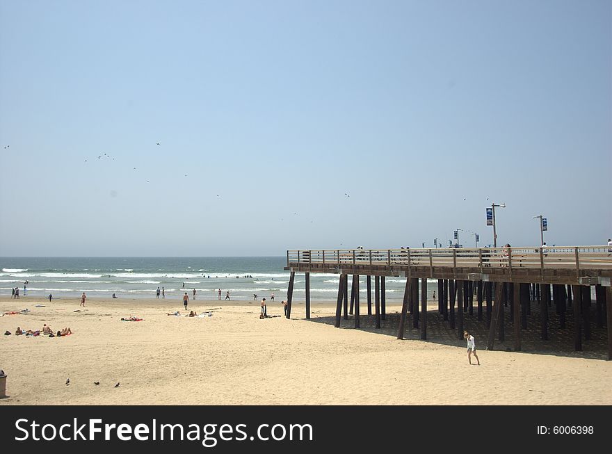 Pier on the beach with the ocean in the background daytime.