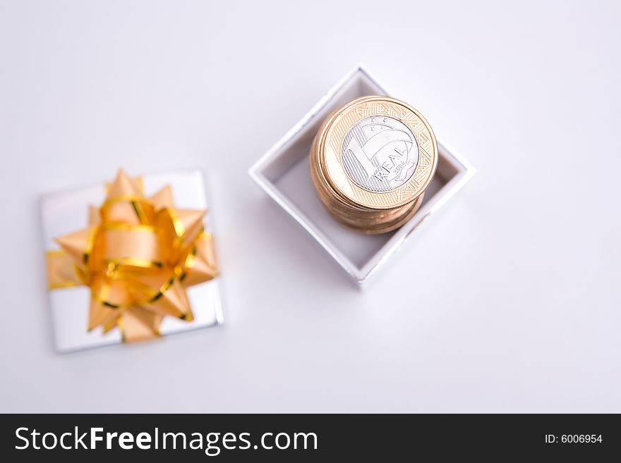 Box to gift and coin on the white background