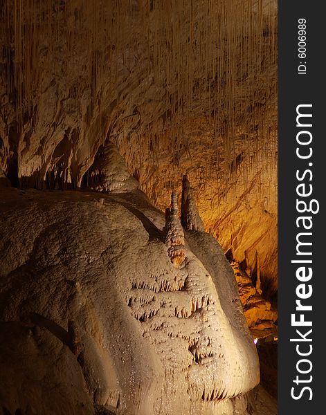 Tall unusual stalagmites and stalactites in the underground cavern in france, vertical