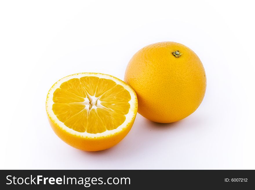 Two bright yellow lemons upon white background. One is cut apart. Two bright yellow lemons upon white background. One is cut apart