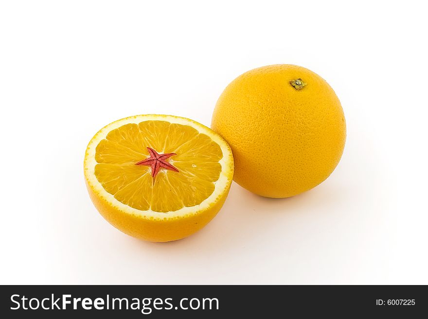 Two bright yellow lemons upon white background. One is cut apart and covered with red sea star. Two bright yellow lemons upon white background. One is cut apart and covered with red sea star