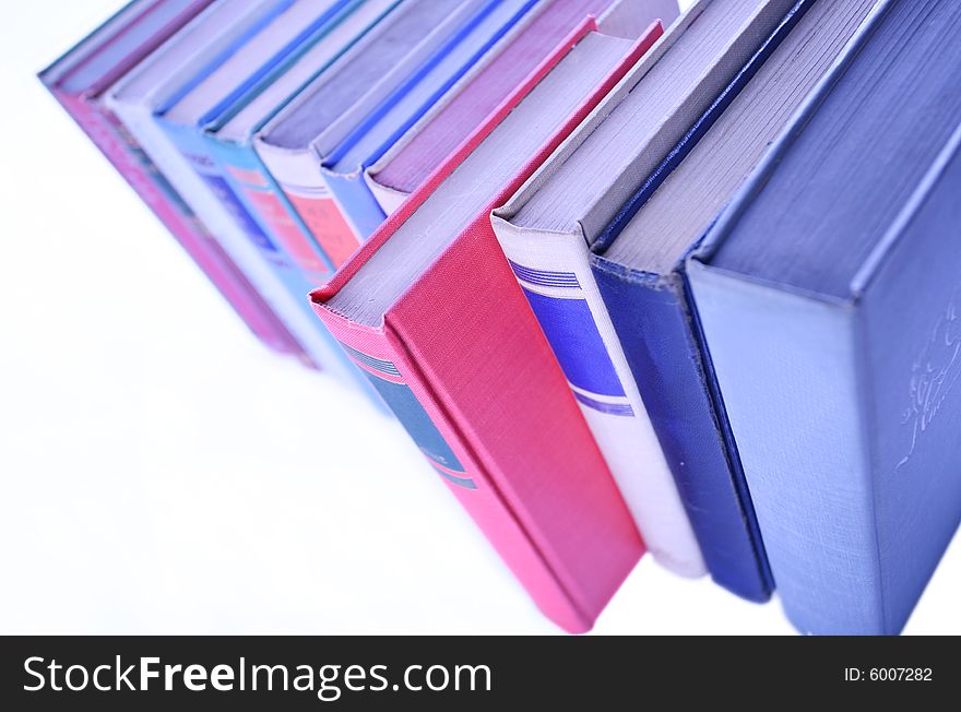 Row of books lined up in row with red book out in front