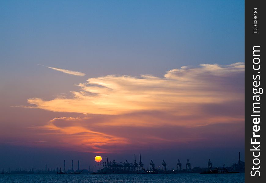 Sun setting over a port and a petrochemical complex. Sun setting over a port and a petrochemical complex