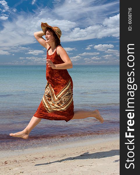 Laughing girl in hat running and jumping at sea shore. Laughing girl in hat running and jumping at sea shore