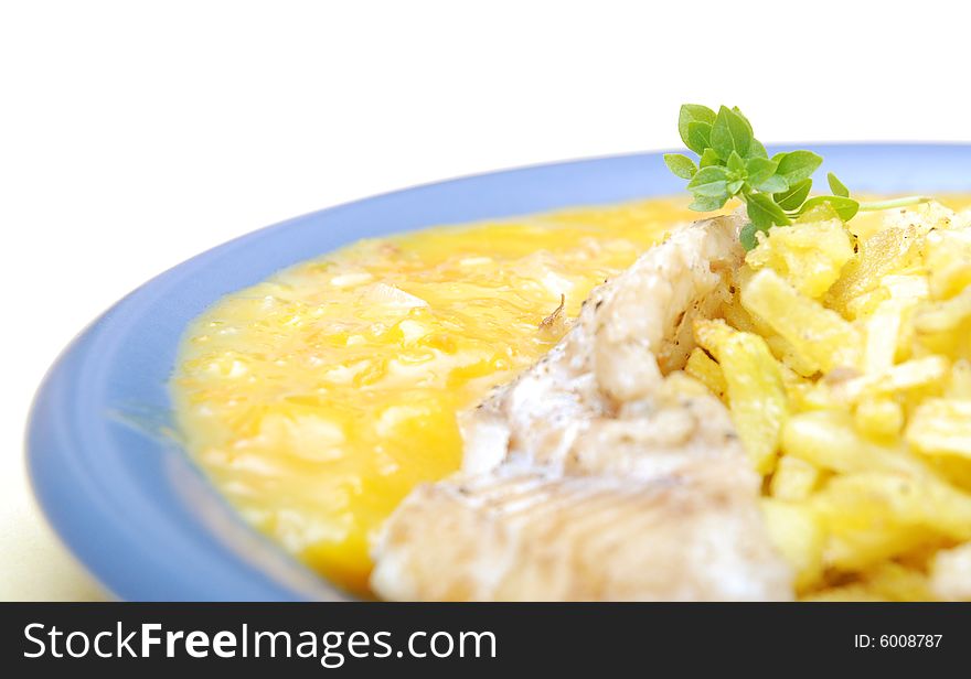 Alaska pollock on thin fries with delicious mango sauce arranged on a blue plate. Close-up, high key, isolated on white background. Alaska pollock on thin fries with delicious mango sauce arranged on a blue plate. Close-up, high key, isolated on white background.