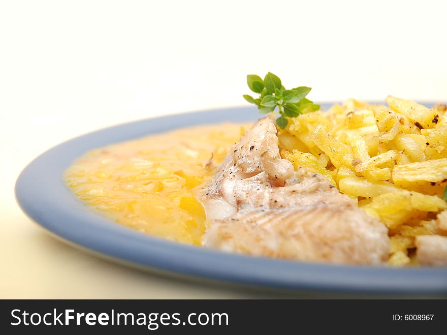 Alaska pollock on thin fries with delicious mango sauce arranged on a blue plate. Close-up. Alaska pollock on thin fries with delicious mango sauce arranged on a blue plate. Close-up.