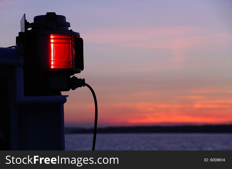 Red lamp on a ship over sunset