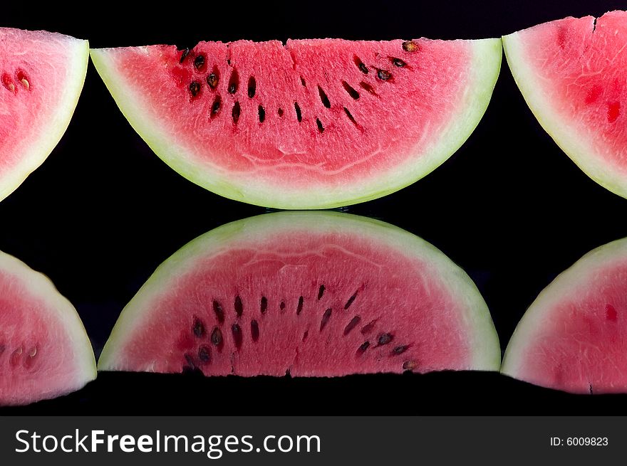 Several pieces of watermelon against the black background. Several pieces of watermelon against the black background