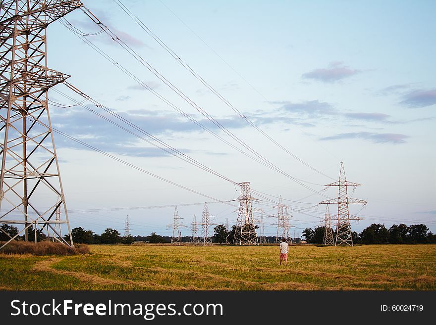 Lonely man walks near power lines. Lonely man walks near power lines