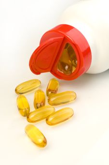 Vitamin Capsules Spilling Out Of A White Bottle Stock Images